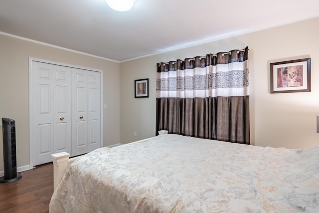 bedroom with crown molding, dark wood-type flooring, and a closet