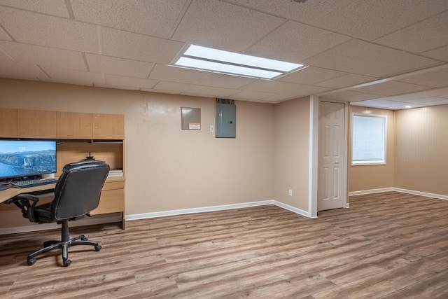 office space with a drop ceiling, electric panel, and light hardwood / wood-style floors