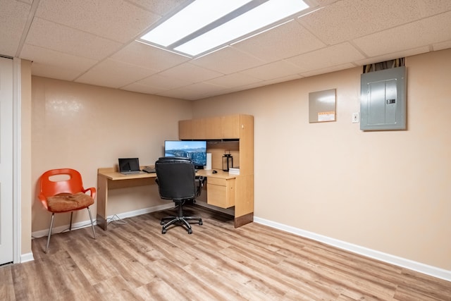 office area featuring a paneled ceiling, electric panel, and light wood-type flooring