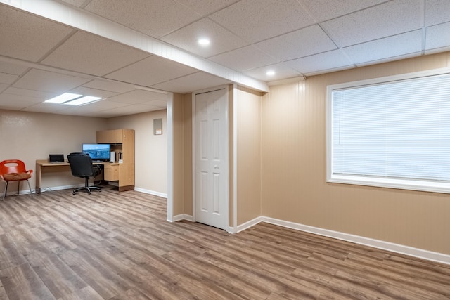 unfurnished office featuring light hardwood / wood-style floors and a drop ceiling