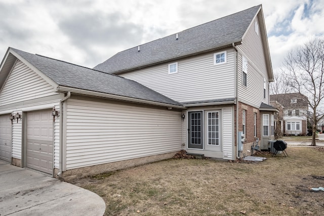 view of side of home featuring a garage and a lawn