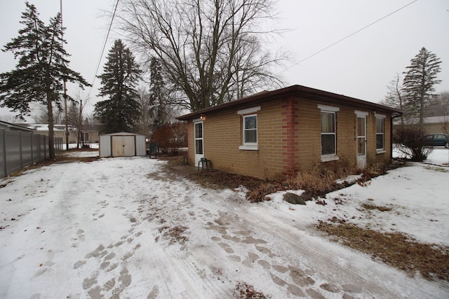 snow covered property featuring a storage unit