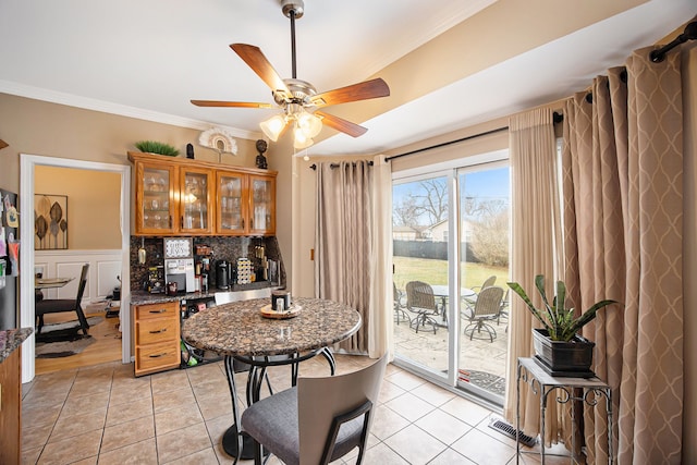 kitchen featuring tasteful backsplash, crown molding, light tile patterned floors, and ceiling fan