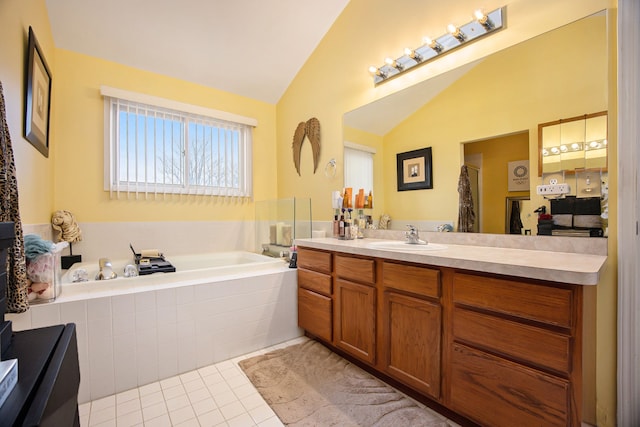 bathroom with tile patterned flooring, vaulted ceiling, a relaxing tiled tub, and vanity