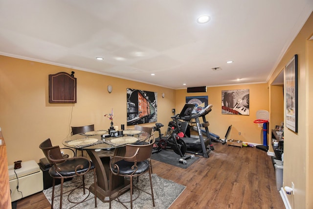 exercise area with hardwood / wood-style flooring and ornamental molding