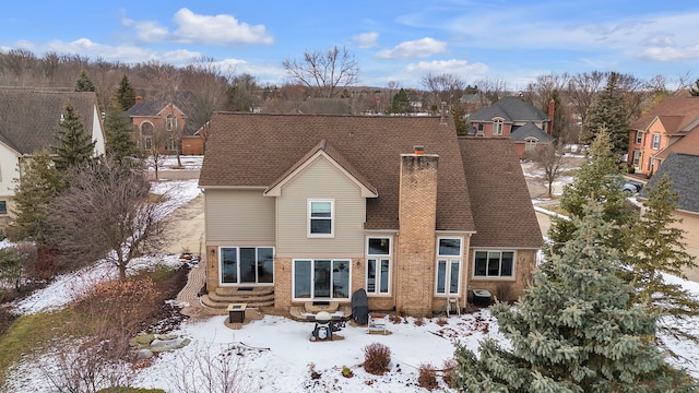 view of snow covered rear of property