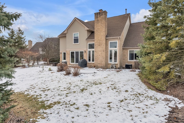 view of snow covered rear of property