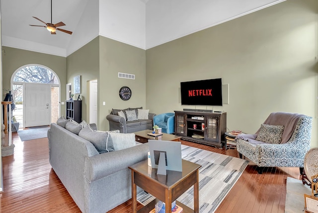 living room with high vaulted ceiling, ceiling fan, and light wood-type flooring