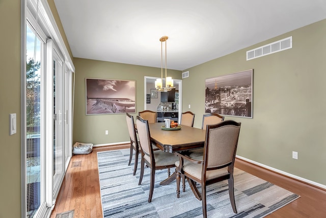 dining area featuring a notable chandelier and light hardwood / wood-style flooring