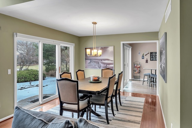 dining space with a notable chandelier and light wood-type flooring