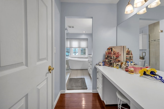 bathroom with vanity, independent shower and bath, and hardwood / wood-style floors