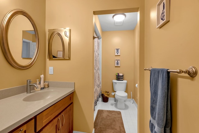 bathroom featuring vanity, tile patterned flooring, and toilet