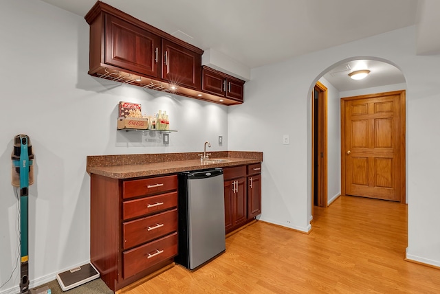 kitchen with sink, stainless steel dishwasher, light hardwood / wood-style floors, and refrigerator