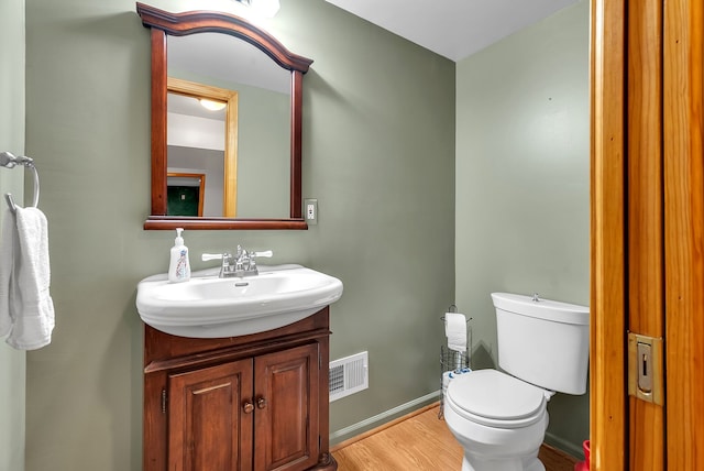 bathroom with vanity, wood-type flooring, and toilet