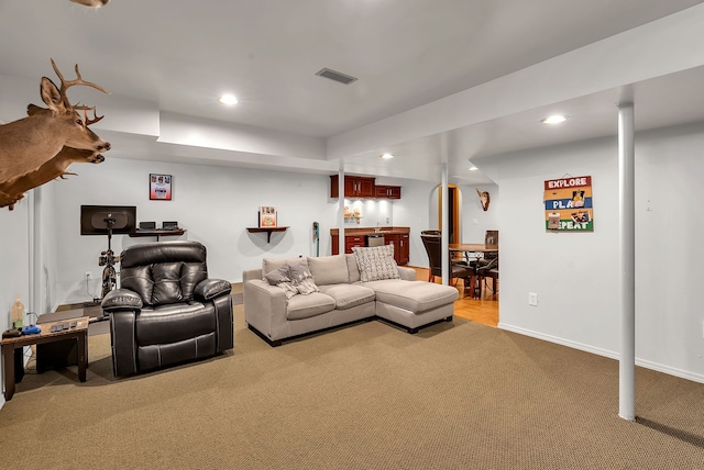 carpeted living room featuring bar area