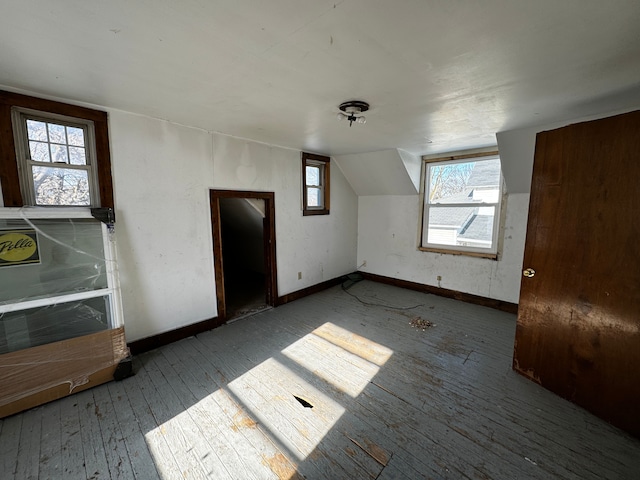 additional living space featuring baseboards, vaulted ceiling, and hardwood / wood-style floors