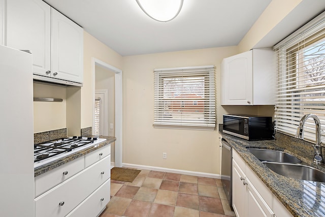 kitchen featuring white cabinetry, appliances with stainless steel finishes, sink, and dark stone counters