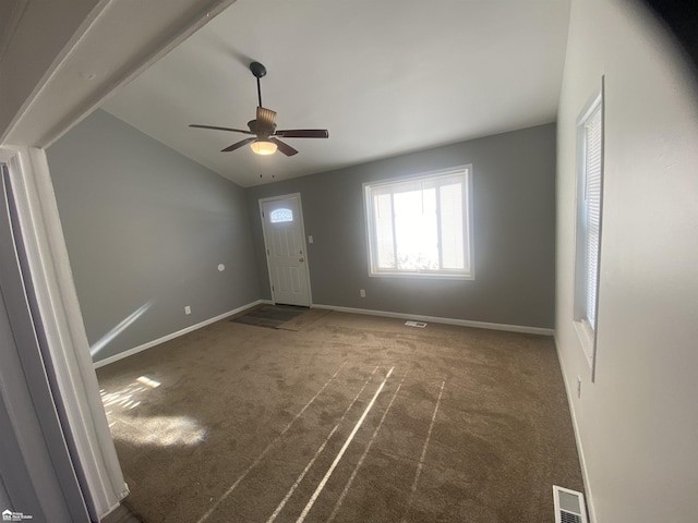 foyer entrance featuring ceiling fan, lofted ceiling, and dark carpet