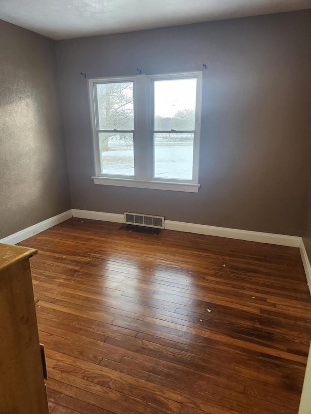 spare room with dark wood-type flooring