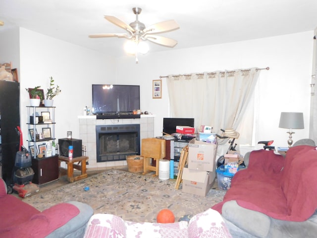 living room with a tiled fireplace and ceiling fan