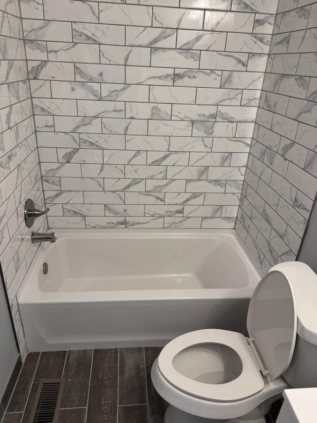 bathroom featuring tiled shower / bath and toilet