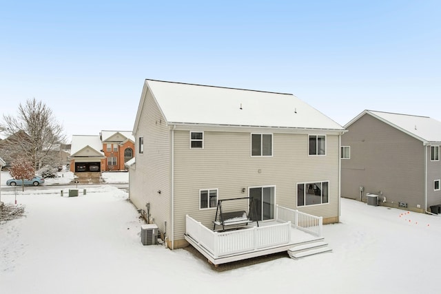 snow covered house featuring central AC