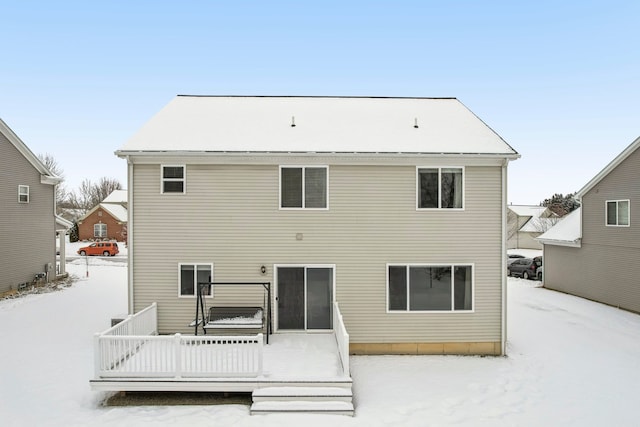 snow covered rear of property featuring a deck