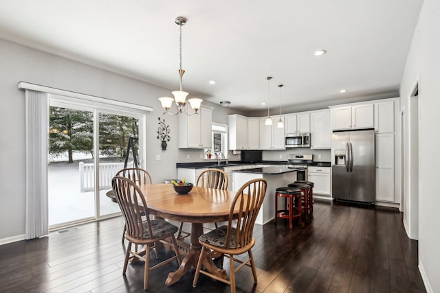 dining space featuring dark hardwood / wood-style floors, a chandelier, and sink