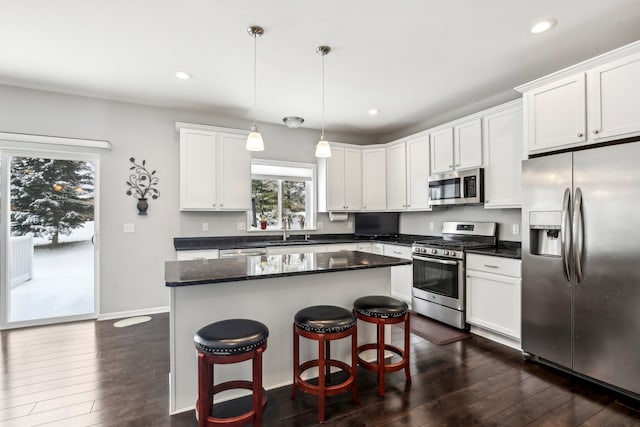 kitchen featuring sink, white cabinetry, a center island, pendant lighting, and stainless steel appliances