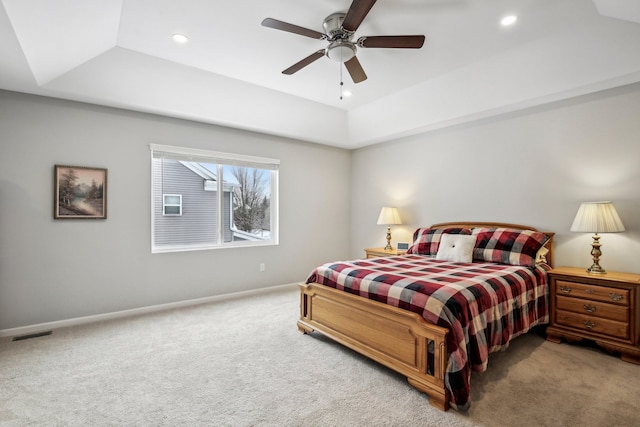 bedroom featuring a tray ceiling, carpet floors, and ceiling fan