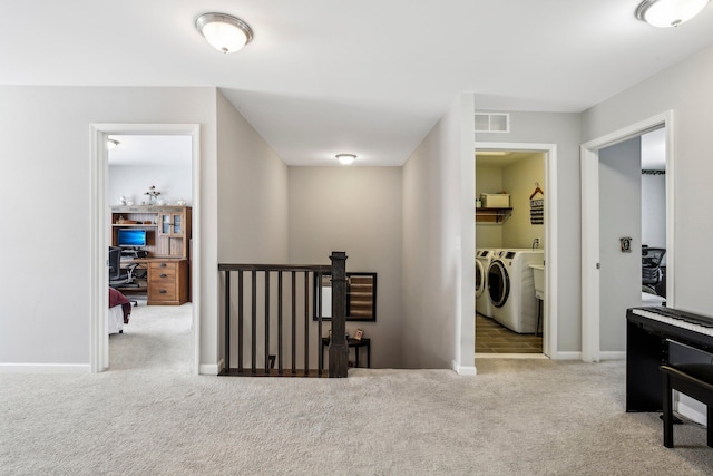 hallway featuring light colored carpet and independent washer and dryer