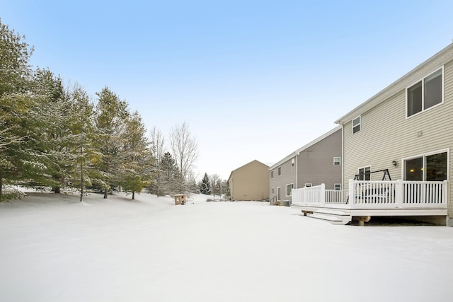 yard covered in snow with a deck