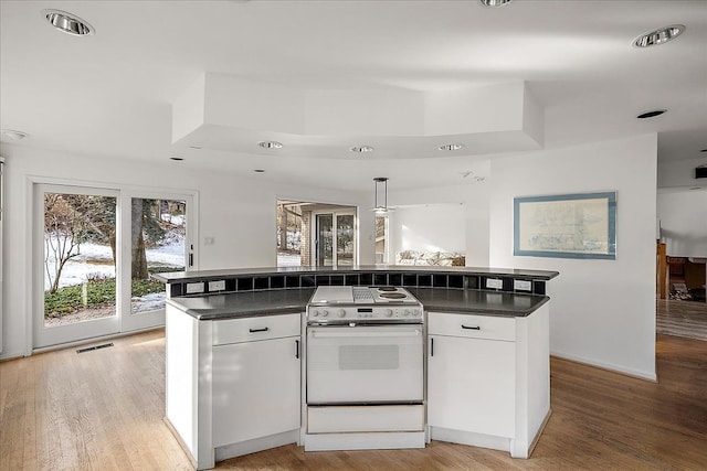 kitchen with pendant lighting, white cabinetry, white electric range oven, and a center island