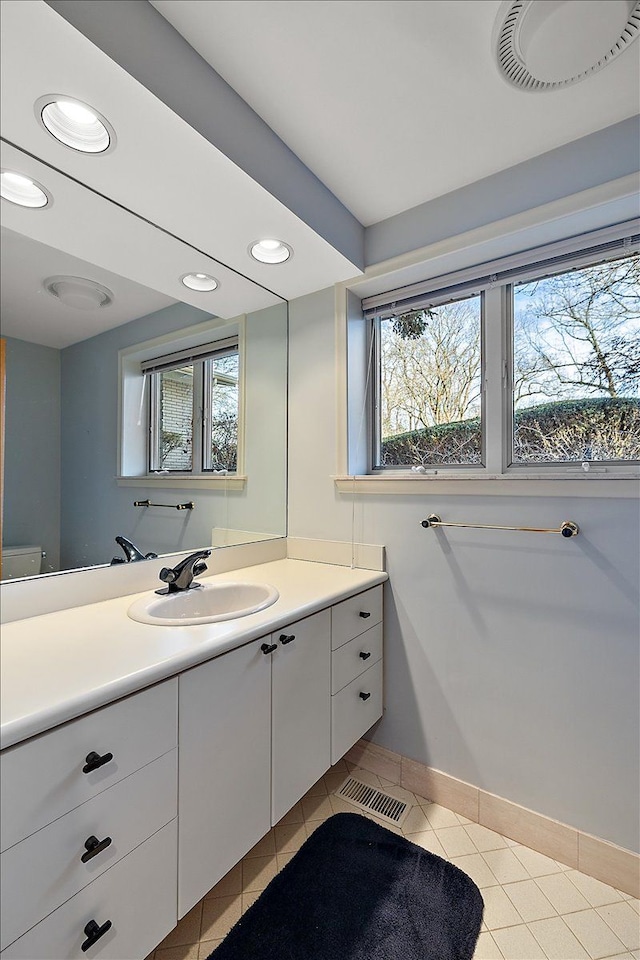 bathroom with tile patterned flooring, vanity, and plenty of natural light