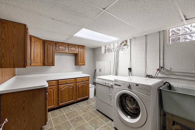 laundry area featuring cabinets, independent washer and dryer, and sink