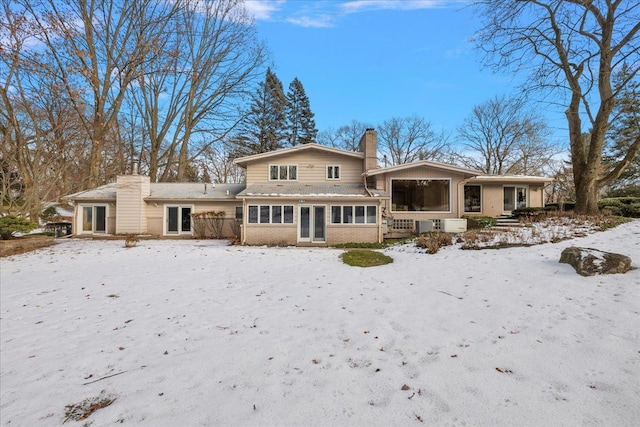 view of snow covered rear of property