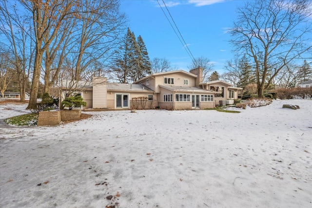 view of snow covered back of property