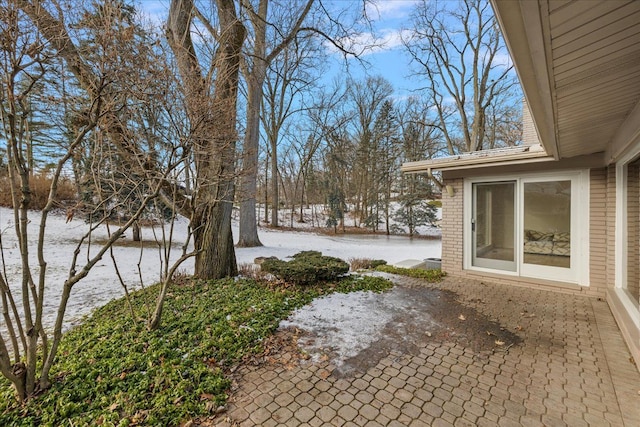 yard layered in snow with a patio