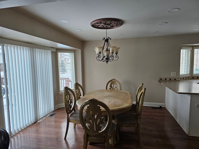 dining area with a chandelier and dark hardwood / wood-style flooring