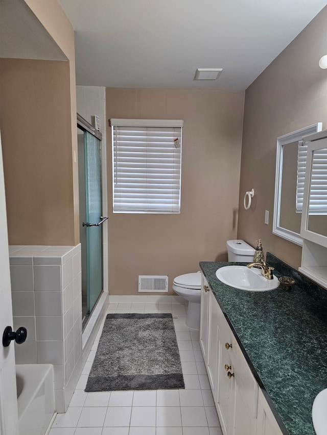 bathroom with vanity, tile patterned floors, toilet, and walk in shower