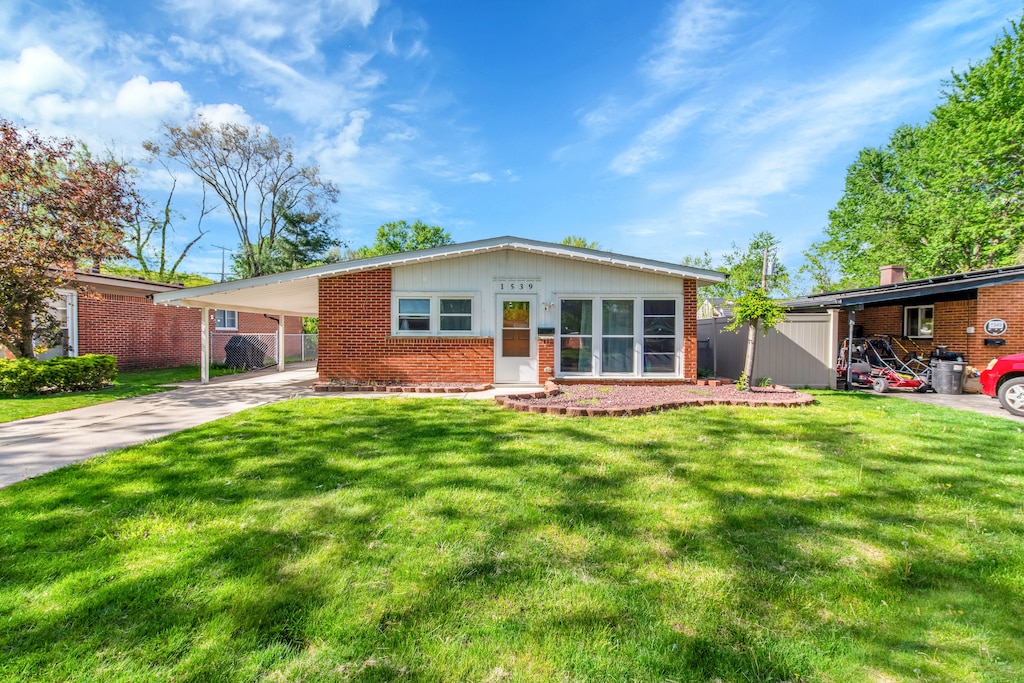 ranch-style house featuring a carport and a front yard