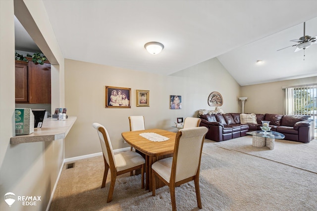 carpeted dining room with lofted ceiling and ceiling fan