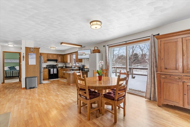 dining space featuring light hardwood / wood-style floors and a textured ceiling