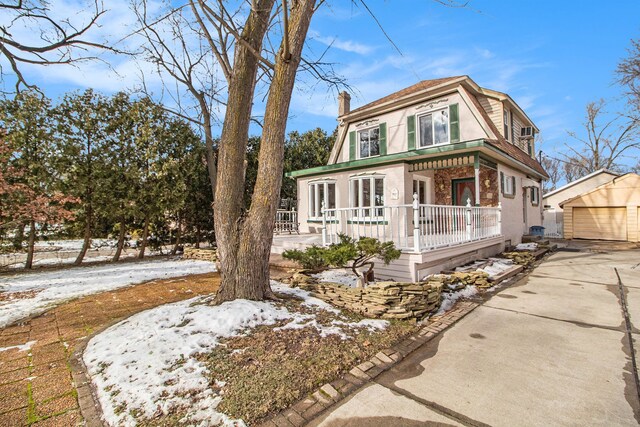 view of front of property with a garage, an outdoor structure, and covered porch