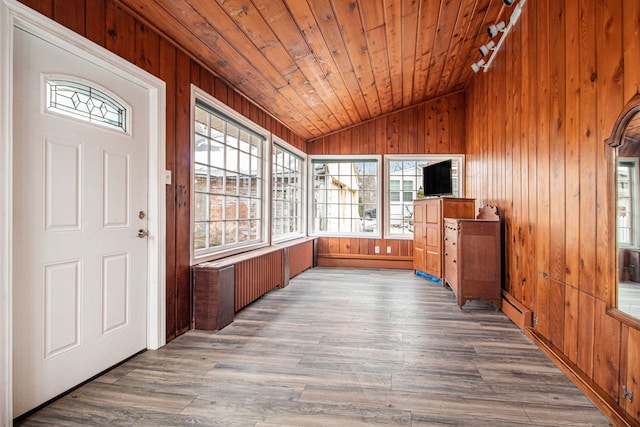 interior space featuring wooden walls, wooden ceiling, wood finished floors, vaulted ceiling, and baseboard heating