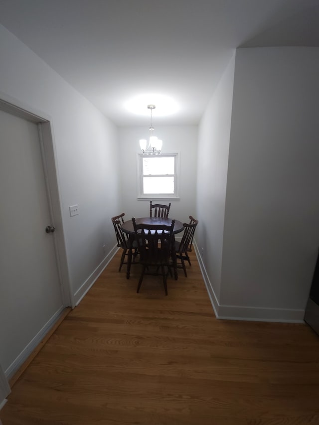 dining area with dark hardwood / wood-style floors and a chandelier