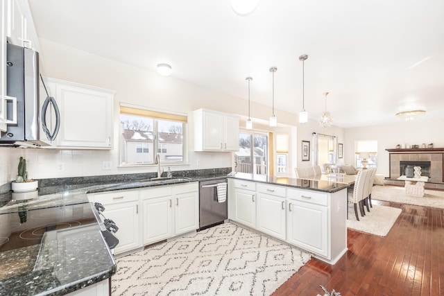 kitchen featuring white cabinetry, hanging light fixtures, stainless steel appliances, and kitchen peninsula