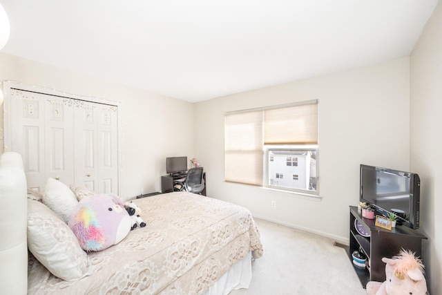 bedroom featuring light colored carpet and a closet