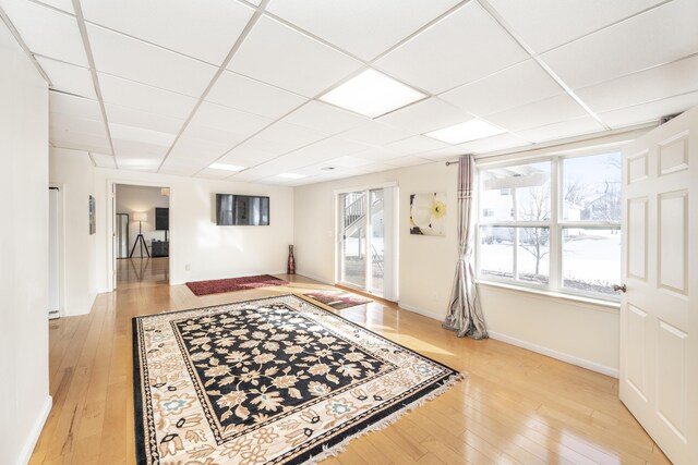 interior space featuring a drop ceiling and light hardwood / wood-style floors