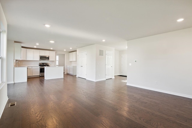 unfurnished living room with dark hardwood / wood-style flooring and sink